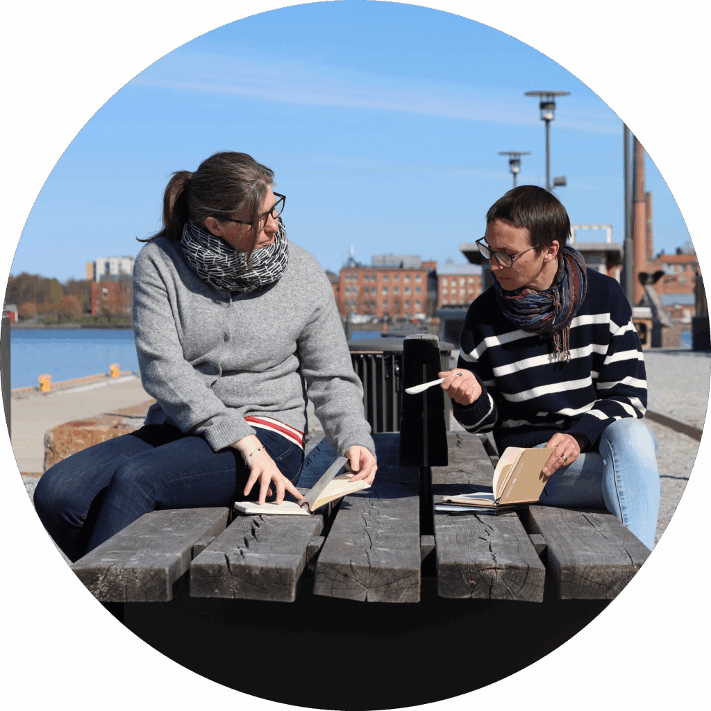 Sara Kåll-Fröjdö and Maria Hofman-Bergholm from Centria University of Applied Sciences sitting in the outdoor office somewhere near the seaside.