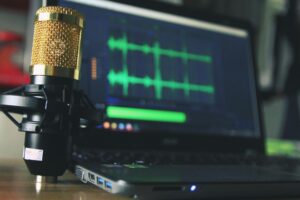 a Laptop and a microphone, ready to record a podcast episode.